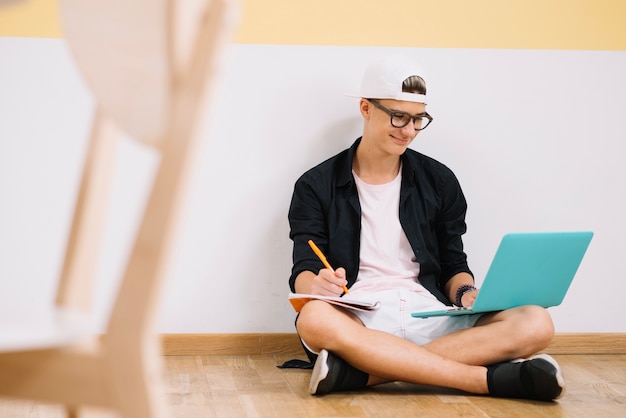 Lächelnder Student posiert Witz Laptop