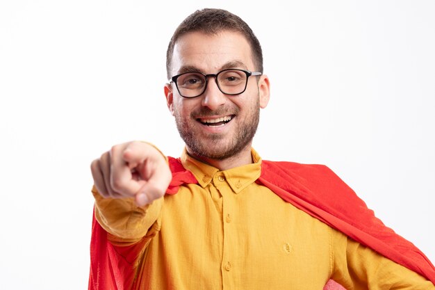 Lächelnder Superheldenmann in optischen Gläsern mit roten Umhangspitzen vorne lokalisiert auf weißer Wand