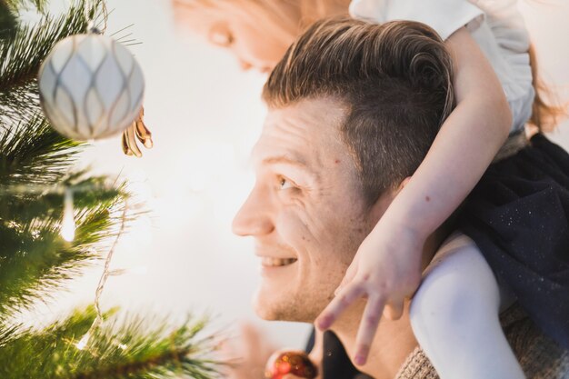 Lächelnder Vater, der beleuchteten Weihnachtsbaum betrachtet