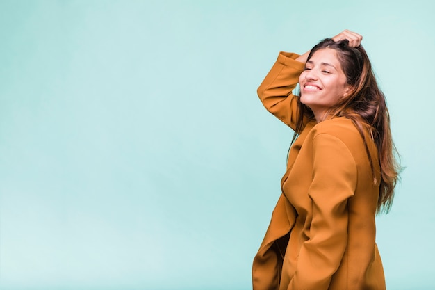 Kostenloses Foto lächelndes brunettemädchen, das mit mantel aufwirft