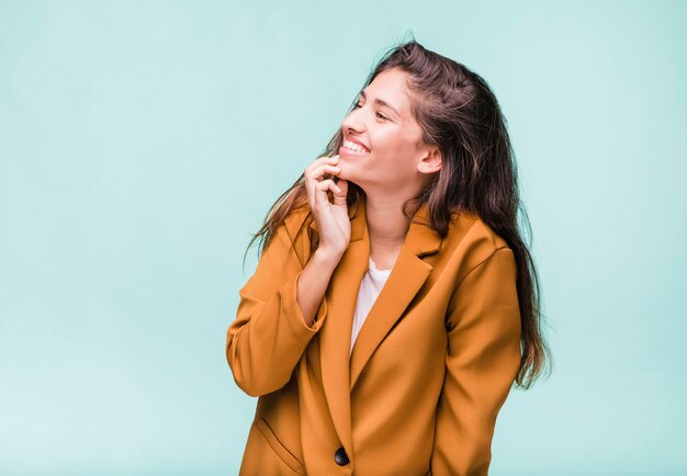 Lächelndes Brunettemädchen, das mit Mantel aufwirft