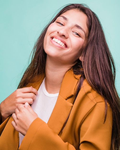 Kostenloses Foto lächelndes brunettemädchen, das mit mantel aufwirft