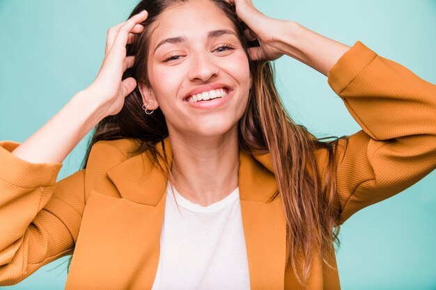 Lächelndes Brunettemädchen, das mit Mantel aufwirft