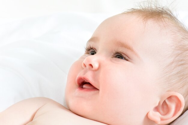 lächelndes Gesicht eines schönen neugeborenen Mädchens