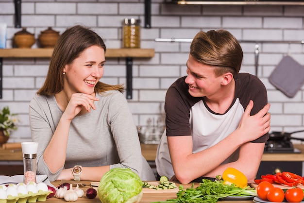 Lächelndes glückliches Paar, das zusammen in der Küche kocht