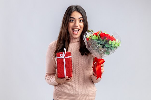 Lächelndes junges Mädchen am Valentinstag mit Geschenkbox mit Blumenstrauß isoliert auf weißem Hintergrund