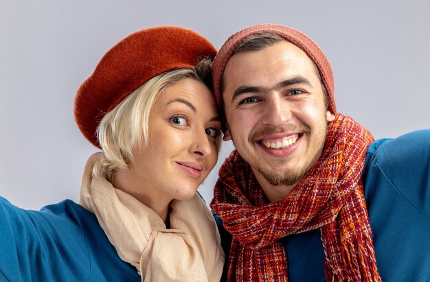 Lächelndes junges Paar am Valentinstag mit Hut mit Schal mit Kamera isoliert auf weißem Hintergrund