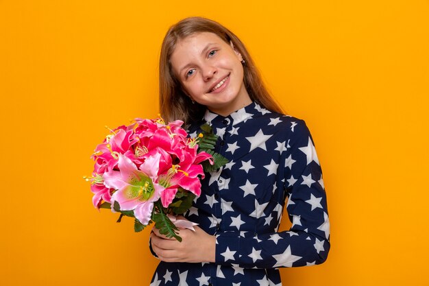 Lächelndes kippendes schönes kleines Mädchen mit Blumenstrauß