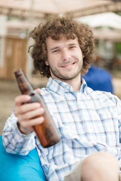 Lächelndes Manngebotsbier zur Kamera