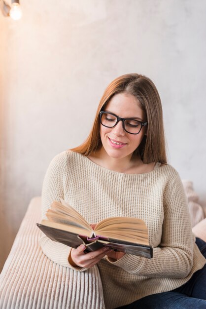 Lächelndes schönes Buch der jungen Frau Lese