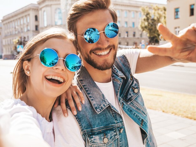 Lächelndes schönes Mädchen und ihr hübscher Freund in der zufälligen Sommerkleidung.