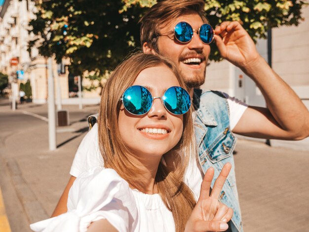 Lächelndes schönes Mädchen und ihr hübscher Freund in der zufälligen Sommerkleidung.