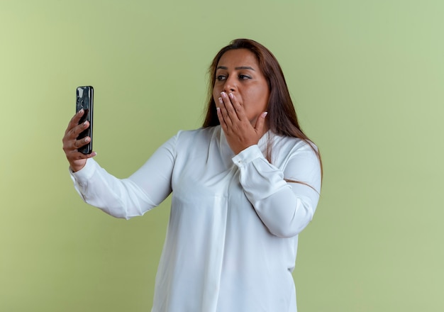 Lässige kaukasische Frau mittleren Alters nehmen ein Selfie und bedeckten den Mund mit der Hand