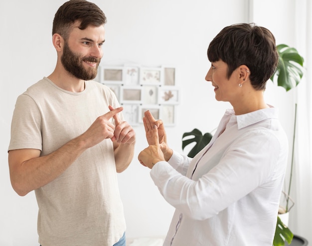 Lässiger Mann und Frau, die durch Gebärdensprache kommunizieren