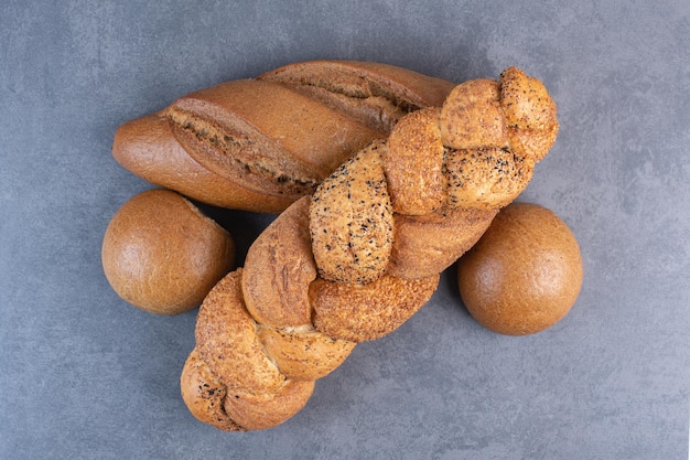 Laibe von Taktstock, Strucia und Brötchen auf Marmorhintergrund gebündelt. Foto in hoher Qualität