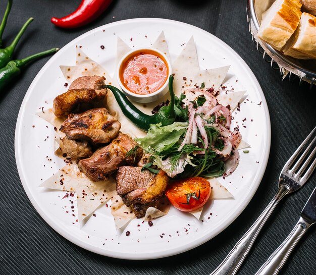 Lammkebab auf Lavash-Zwiebelgrün-Tomaten-Salat-Pfeffer-Draufsicht