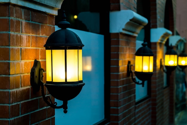 Lampe gegen eine rote Mauer in der Nacht.