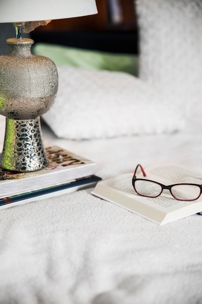 Kostenloses Foto lampe und brille auf bücher