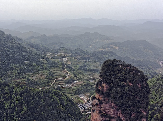 Kostenloses Foto landschaft aus felsigen bergen mit viel grün und nebel - ideal für tapeten