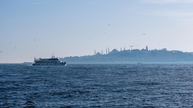 Landschaft der Istanbul-Gebäude im Abstand und ein türkisches schwimmendes Boot