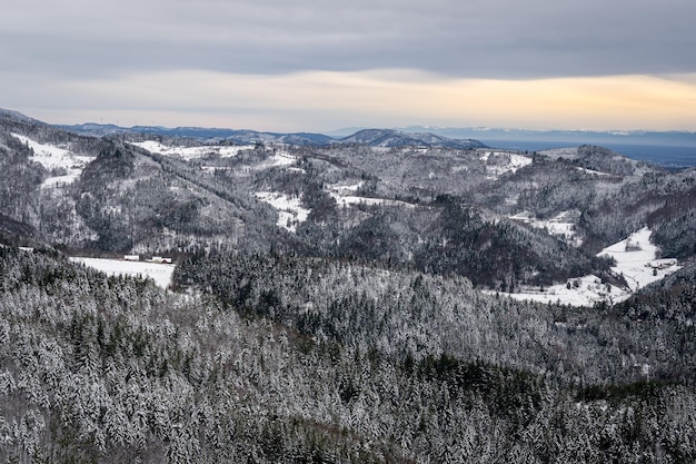 Landschaft der Schwarzwaldberge, die während des Sonnenaufgangs in Deutschland mit Schnee bedeckt sind