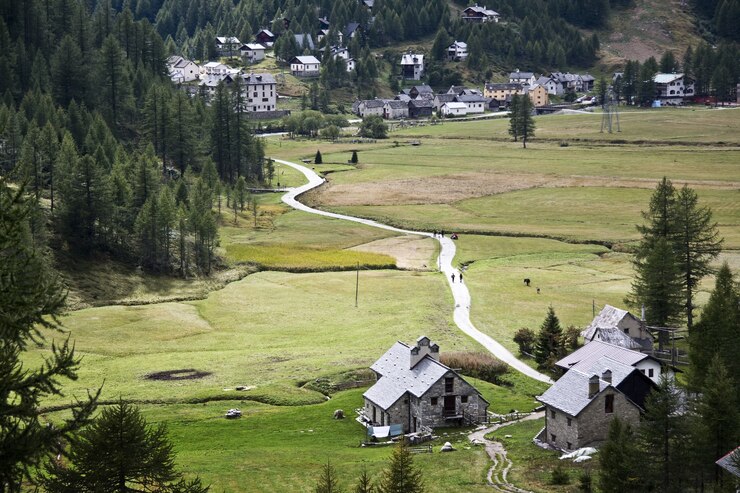 Kostenlose Foto landschaft des dorfes umgeben von hügeln, die tagsüber mit viel grün bedeckt sind