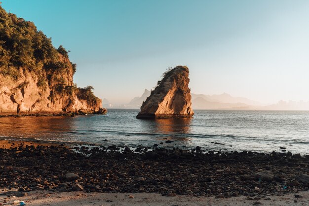 Landschaft des Sonnenuntergangs mit einer schönen Felsformation am Strand von Rio De Janeiro, Brasilien