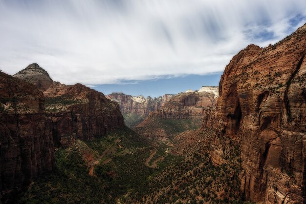 Landschaft des Zion-Nationalparks unter dem Sonnenlicht und einem bewölkten Himmel in Utah