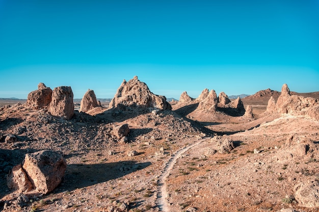Landschaft einer Wüste mit leerer Straße und Klippen unter dem klaren Himmel