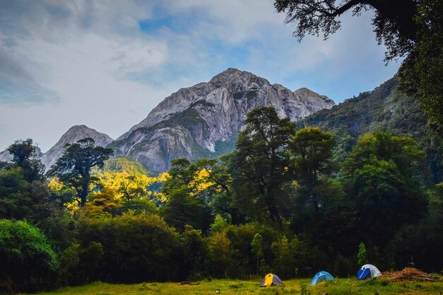 Landschaft eines Campingplatzes mit Zelten auf einem von felsigen Hügeln umgebenen Feld
