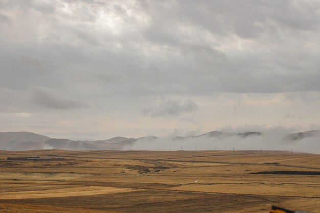 Landschaft umgeben von hohen Bergen unter den Gewitterwolken