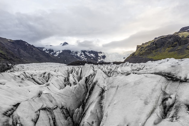 Landschaft von Ödland bedeckt mit Eis unter einem bewölkten Himmel in Island