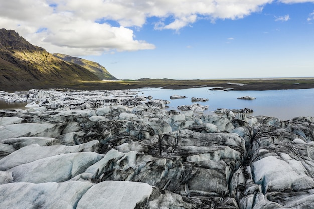 Kostenloses Foto landschaft von eisbedeckten ödländern, umgeben von wasser unter dem sonnenlicht