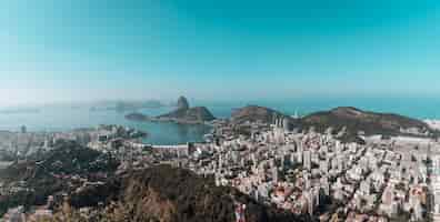 Kostenloses Foto landschaft von rio de janeiro, umgeben vom meer unter einem blauen himmel in brasilien