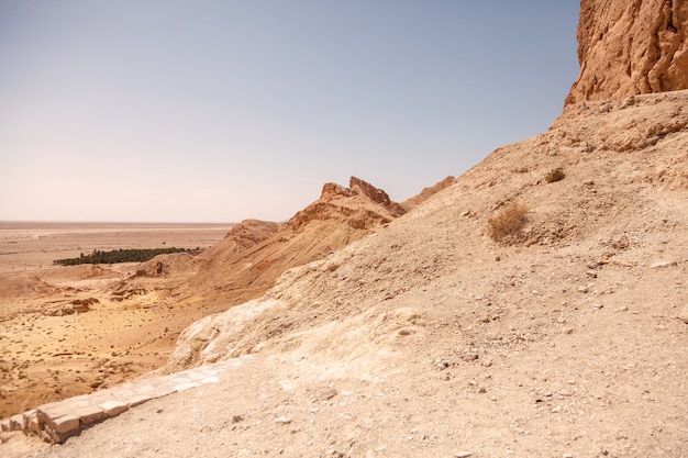 Landschafts-chebika-oase in der sahara-wüste. blick auf die berglandschaft. bergoase mit malerischer aussicht in nordafrika. das hotel liegt am fuß des jebel el negueba. atlasgebirge am sonnigen nachmittag. tozeur, tunesien