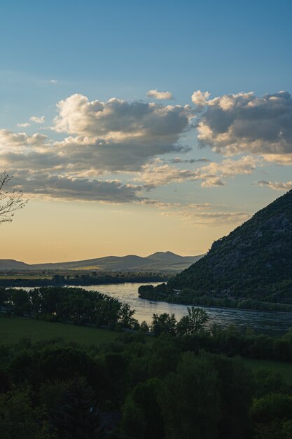 Landschaftsansicht der Hügel am Ufer eines ruhigen Sees unter dem blauen Himmel