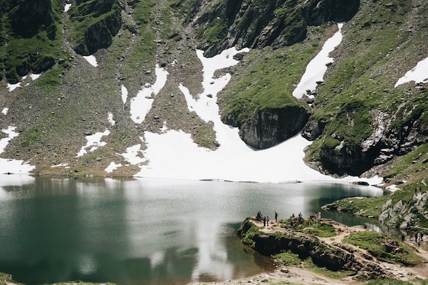 Landschaftsansicht des Balea-Sees in Rumänien und des Fagaras-Gebirges im Sommer mit schneebedeckten Gipfeln