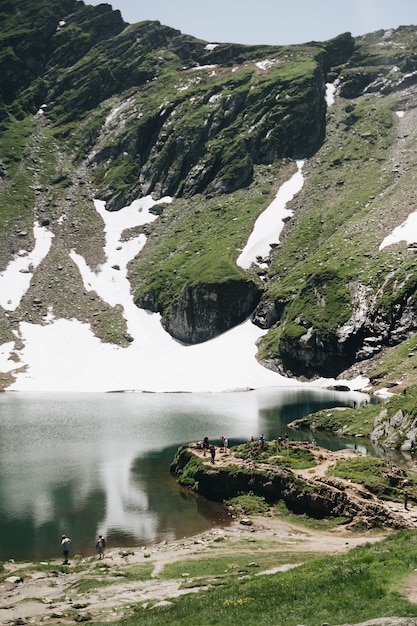 Landschaftsansicht des Balea-Sees in Rumänien und des Fagaras-Gebirges im Sommer mit schneebedeckten Gipfeln