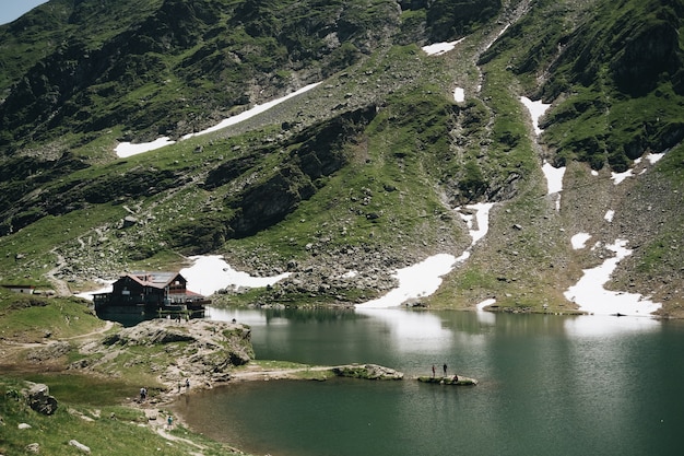 Landschaftsansicht des Balea-Sees in Rumänien und des Fagaras-Gebirges im Sommer mit schneebedeckten Gipfeln