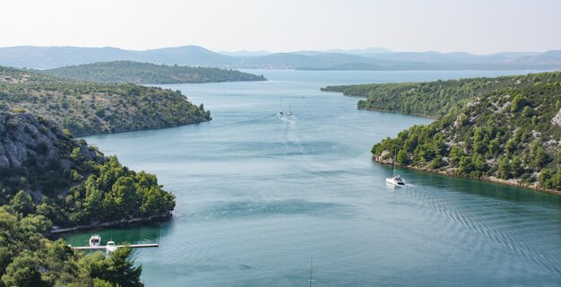 Landschaftsansicht des Flusses Krka in Kroatien, umgeben von Bäumen und Bergen