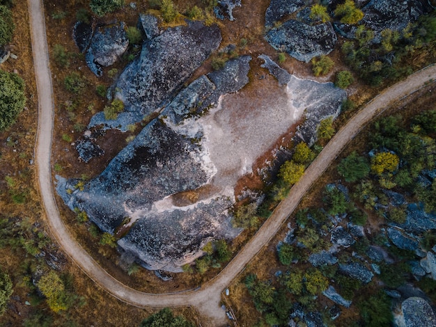 Landschaftsansicht mit rauen Felsen und kurvenreicher Straße im Naturgebiet von Barruecos, Extremadura, Spanien