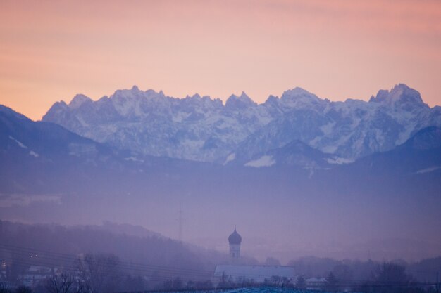 Landschaftsaufnahme einer purpurroten Landschaft mit Bergorangenhimmel im Hintergrund