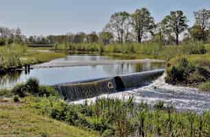 Kostenloses Foto landschaftsaufnahme eines kleinen ländlichen wasserfalls am frühlingstag