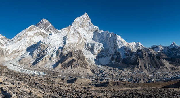 Kostenloses Foto landschaftsaufnahme eines schönen tals, umgeben von riesigen bergen mit schneebedeckten gipfeln