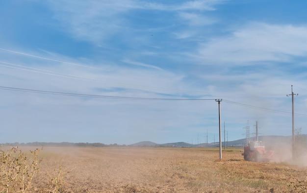 Landwirt auf einem Traktor bereitet das Land mit einem Kultivator im Rahmen der Vorsaatarbeiten während der landwirtschaftlichen Saison auf dem Land vor