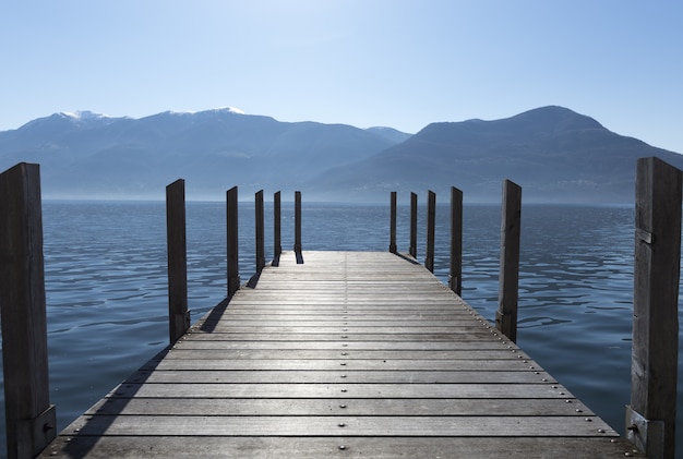 Lange Aufnahme der Docks, die sich bis zum See erstrecken, mit Bergen am Horizont