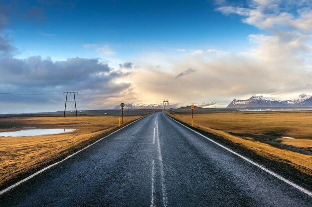 lange gerade Straße und blauer Himmel, Island.