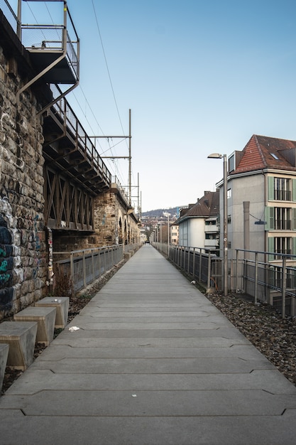 Langer gepflasterter Weg neben den Bögen eines Viadukts unter bewölktem Himmel