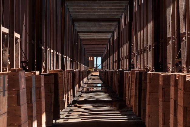 Langer Korridor im Industriegebäude mit Schatten der Säulen auf dem Boden