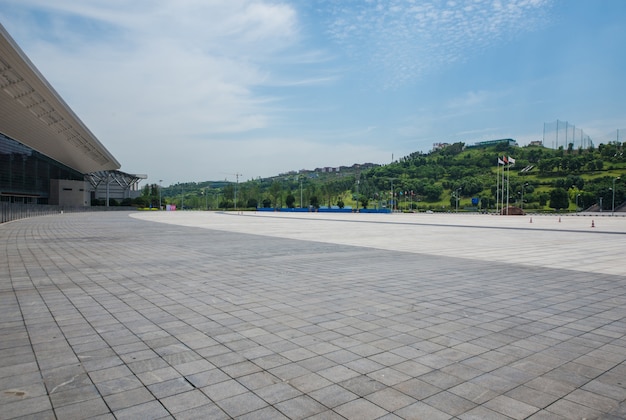 Langer leerer Fußweg im modernen Stadtplatz mit Skyline